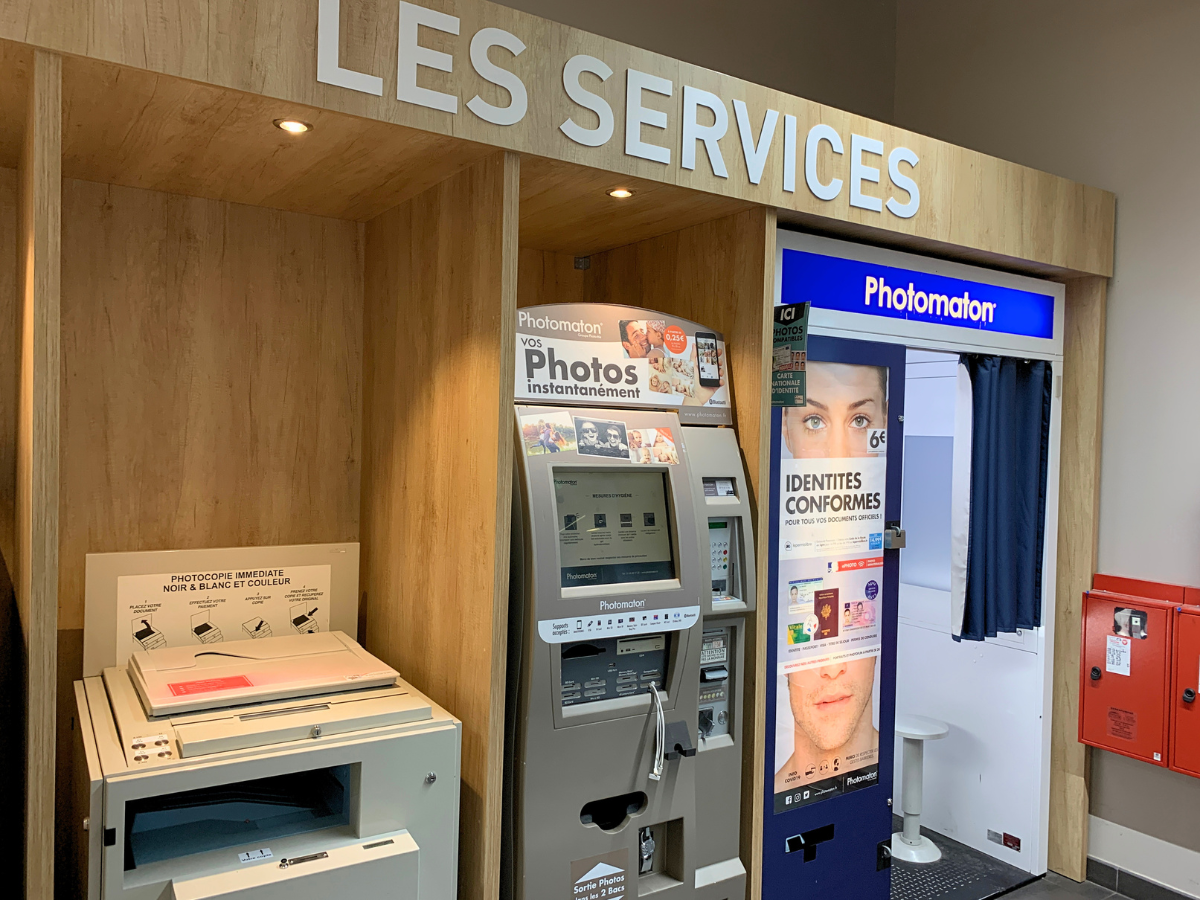 Espace services Intermarché avec mobilier en bois sur mesure pour Photomaton et services clients