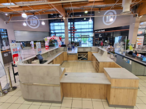 Banque d’accueil centrale sur mesure avec comptoirs et rangements intégrés en grande surface