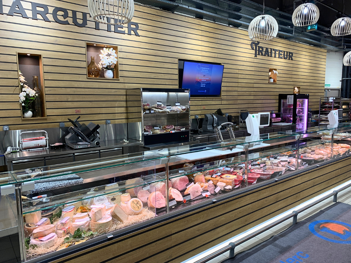 Agencement sur mesure d’un rayon charcuterie traiteur avec habillage bois en grande surface