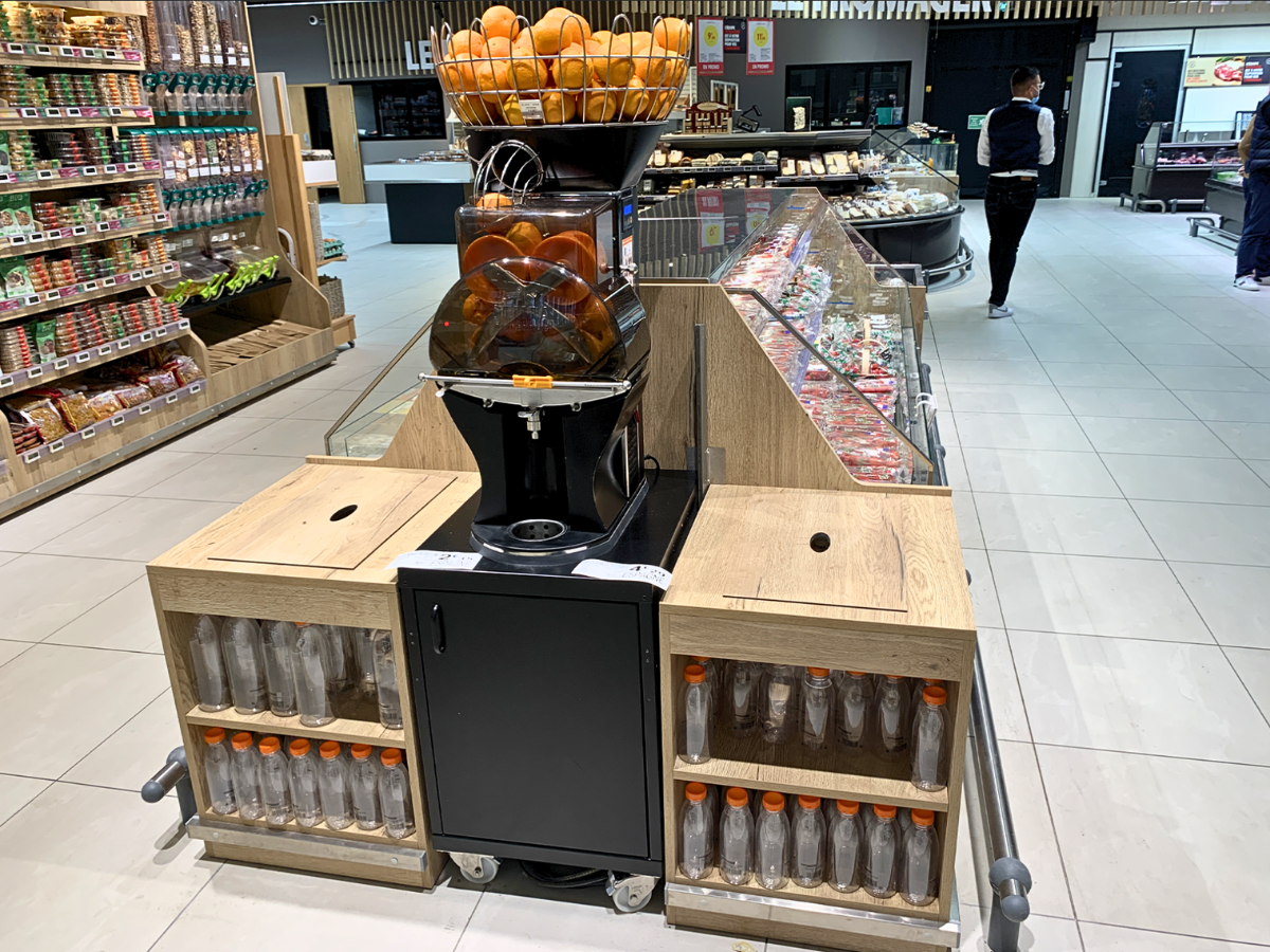Meuble sur mesure pour presse-agrumes et bouteilles de jus frais en grande surface