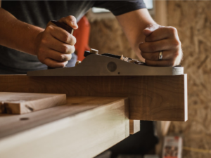 Travail manuel du bois au rabot pour la fabrication de mobilier sur mesure