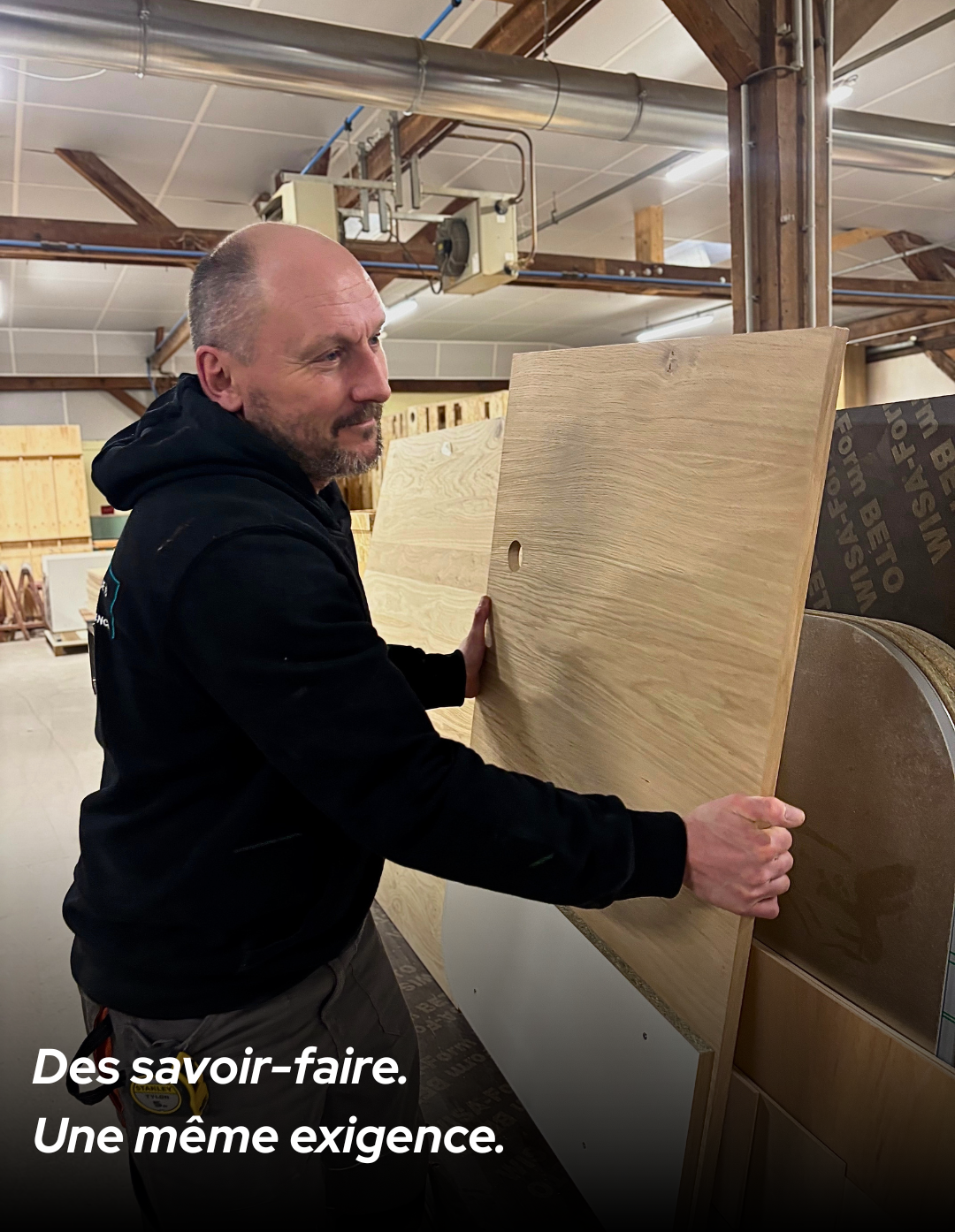 Artisan agenceur manipulant un panneau en bois dans l’atelier de fabrication MSG Vidal Agencement