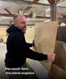 Artisan agenceur manipulant un panneau en bois dans l’atelier de fabrication MSG Vidal Agencement